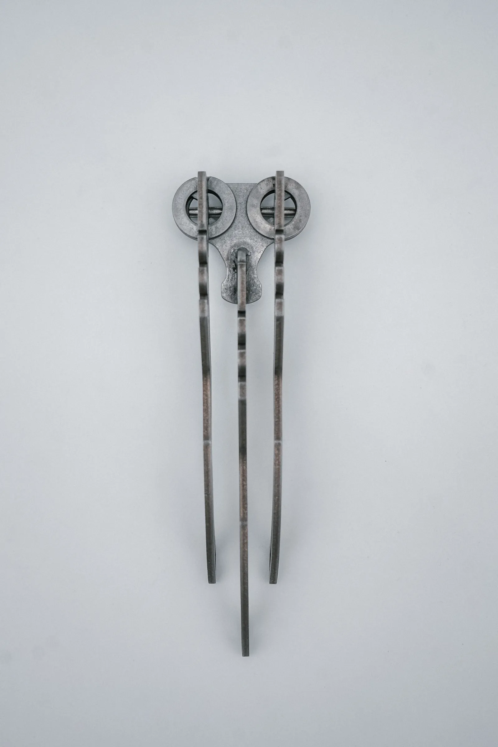 The stand folded flat, legs stacked on one pivot