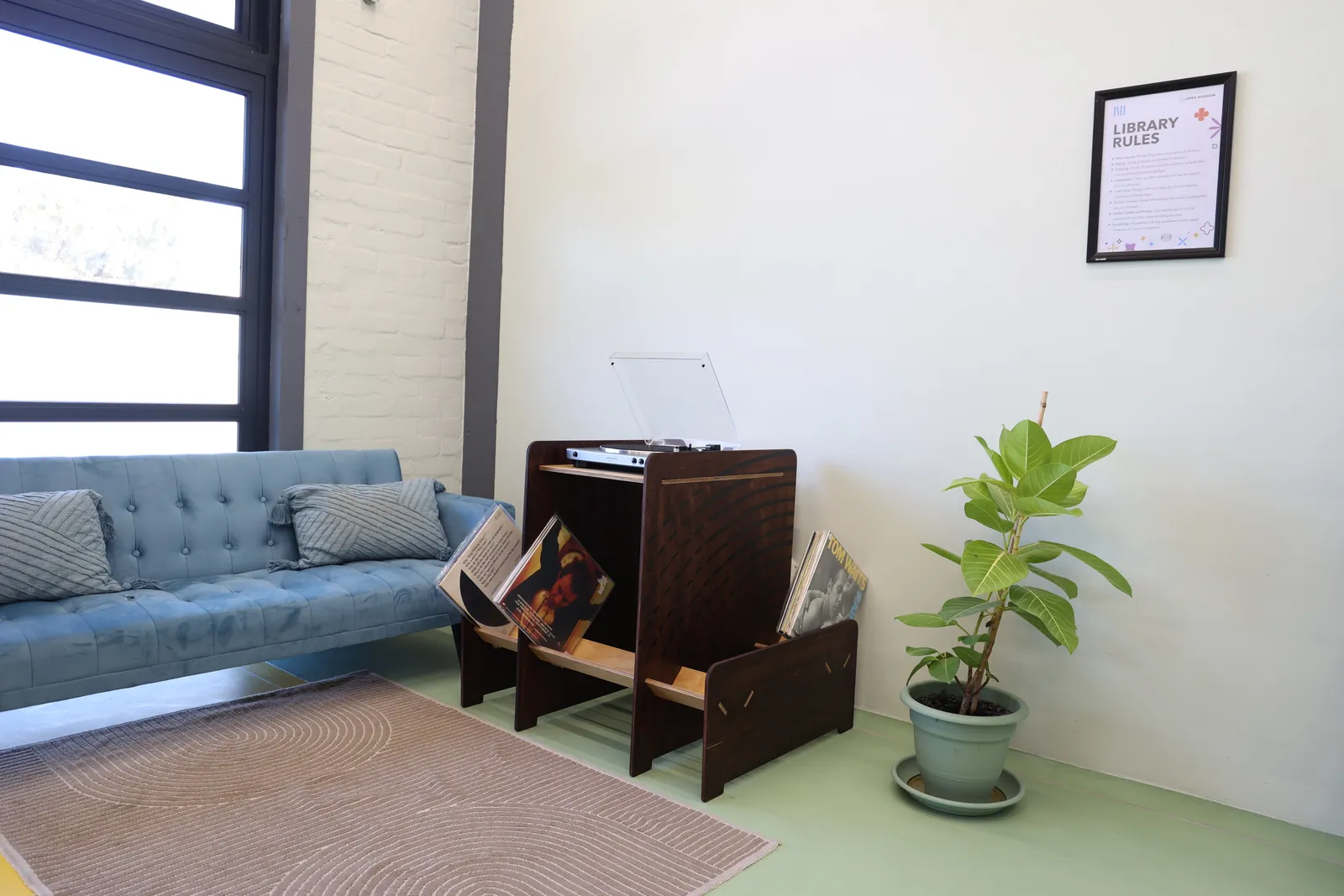 The unit in the corner of a lounge next to a sofa and plant