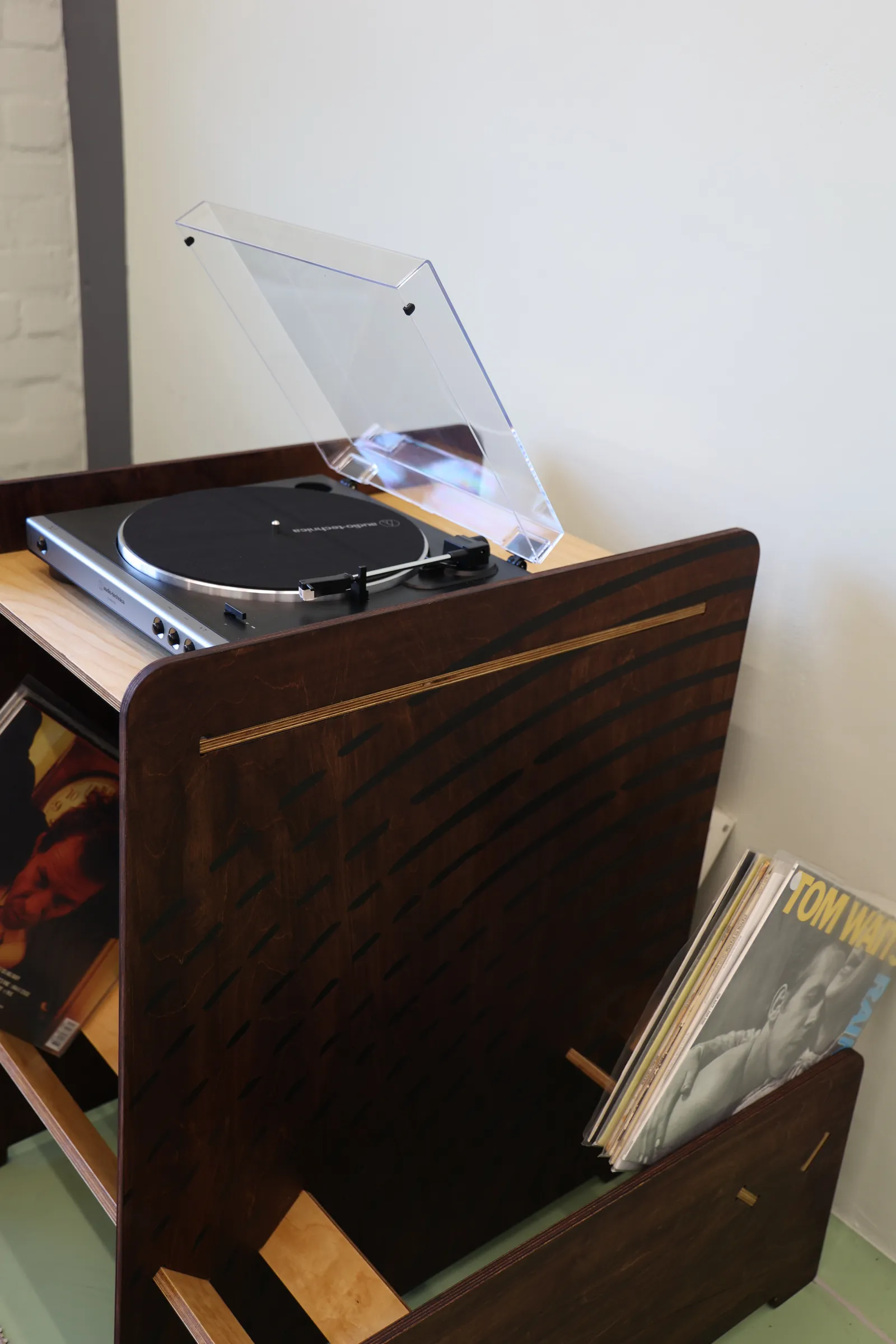 Close-up of the stained birch side panel and records leaning in the bay