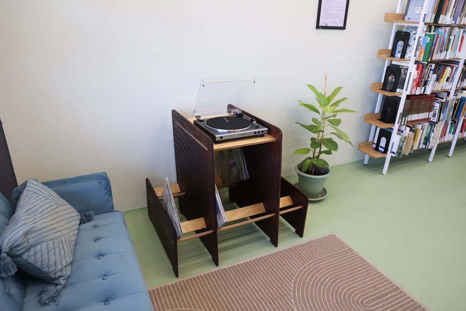 The flatpack vinyl unit in a lounge with a turntable on top and records in the side bays