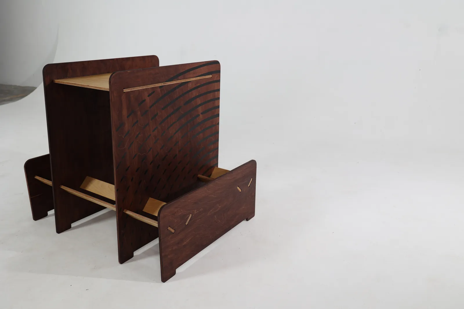 Studio photo of the unit three-quarter view, stained ply with routed line pattern